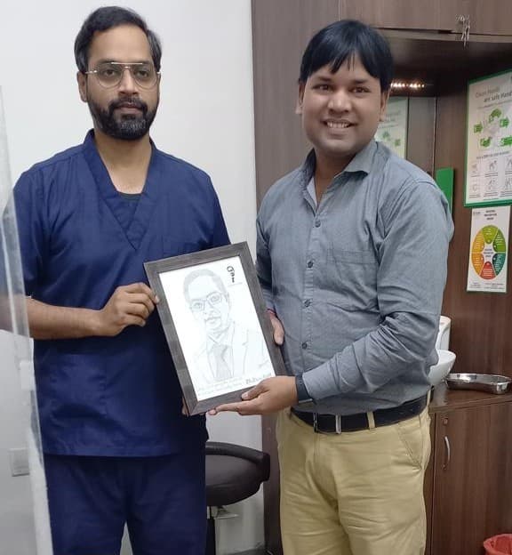 Dr. Savyasachi Saxena receiving a hand-drawn portrait from a patient
